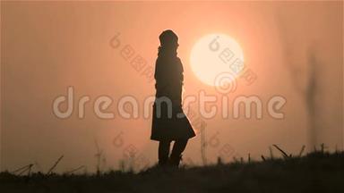 年轻女孩遇见新的一天。 女人跑步，黎明时散步。 黎明的女孩在太阳的圆圈里。